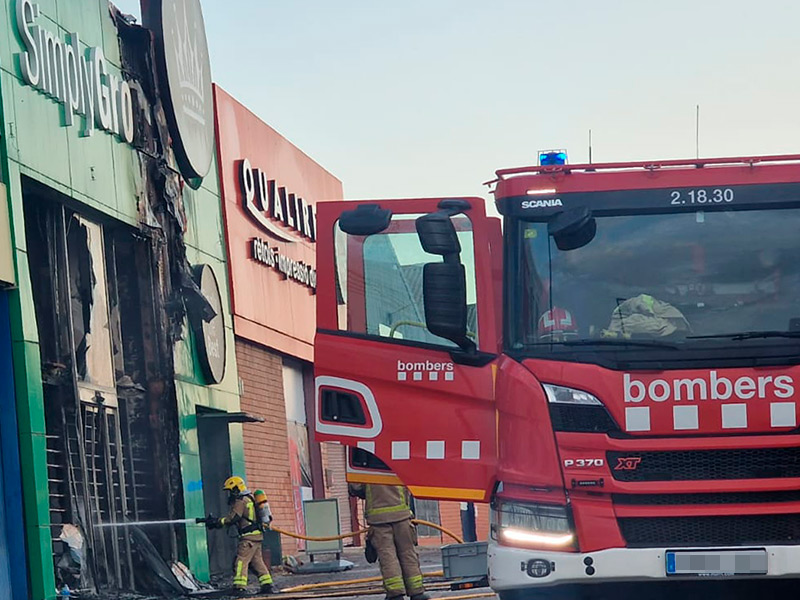 Bombers de la Generalitat treballant a quarts de vuit del matí per acabar d'apagar el foc que ha cremat la nau. (Foto: Marcos Terol).