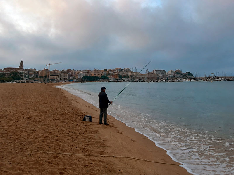 La normativa només permet pescar a Palamós des de la platja entre les 10 de la nit i les 6 del matí. (Foto: Generada amb IA).