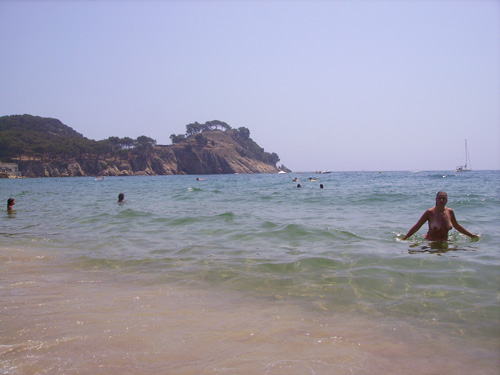Banyistes a la platja de Castell, aquest matí, amb les aigües ja netes.
