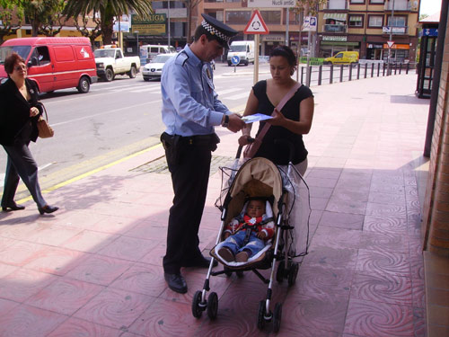 Un agent de la Policia Local de Palamós repartint material informatiu, aquest matí.