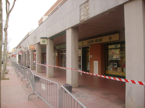 El tram de vorera tancat, amb la façana en plena remodelació.