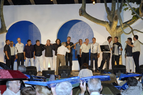 Els grups canten 'El meu avi', amb el públic protegint-se de la pluja. (Fotografia   cedida per Josep Lois).