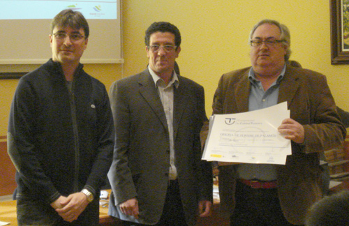 El president del Consell Comarcal, Ricard Herrero, al centre, lliura la distinció al regidor Antoni Bachiller.
