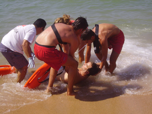 Socorristes fent un simulacre a la platja Gran de PalamÃ³s.