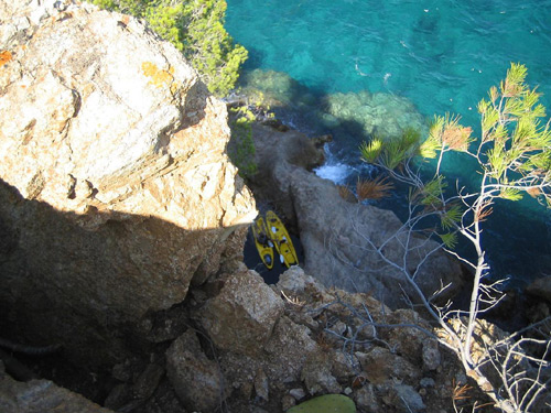 La roca, en primer terme, i uns caiacs navegant per sota.
