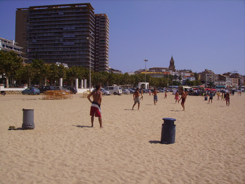 Un grup de gent juga a futbol a la platja Gran de Palamós.