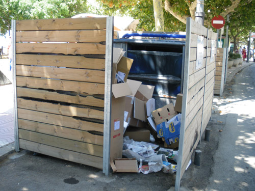 Contenidor de paper al passeig, ahir. Tot i que és mig buit, les deixalles s'acumulen al terra.