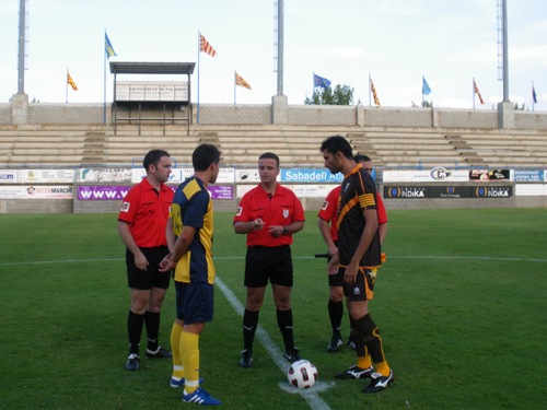 Els capitants del Palamós i el Badalona, amb l'àrbitre, just abans de començar el partit.