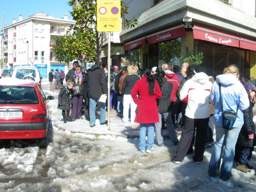 Cues per comprar pa durant l'apagada de llum a Palamós.