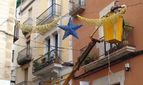 Un operari de la brigada municipal col·locant llums de Nadal.
