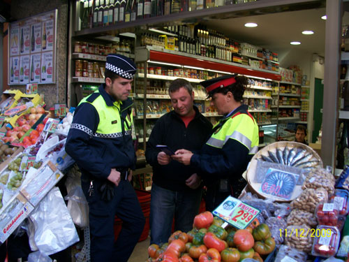 Un agent dels Mossos i un de la Policia Local en una botiga del carrer Major.