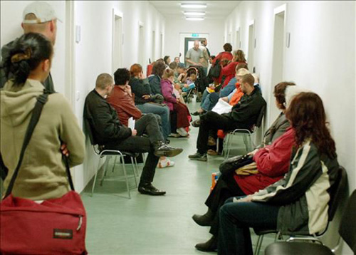 Un grup de persones s'espera a l'Oficina de Treball.