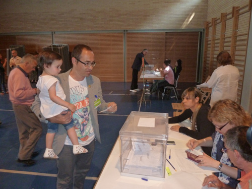 Èrik Solés, amb la seva filla, diposita el seu vot al col·legi Ruiz Giménez.