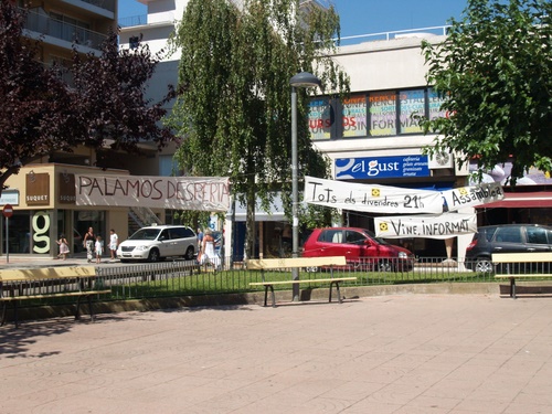 Pancartes d'Acampada Palamós a la plaça de Catalunya.