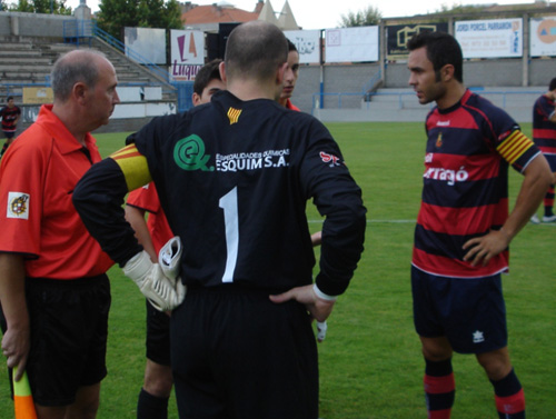 El porter del Palamós, Joan Bayona, d'esquena, amb el capità del Llagostera. (Foto: Sergi Cortés).