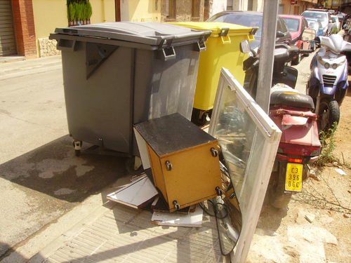 Contenidors d'escombraries plens de brossa, a Palamós.