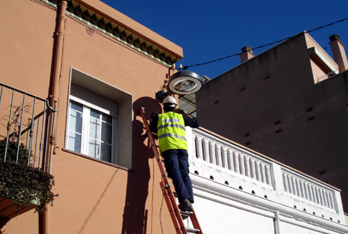 Un operari instal·lant noves lluminàries en un carrer de Palamós.