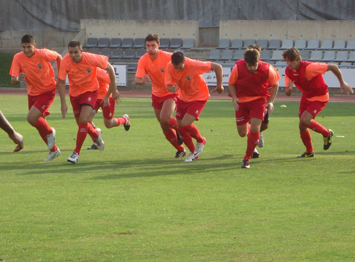 Els jugadors del Palamós fent l'escalfament al camp del Gavà. (Foto: Sergi Cortés).