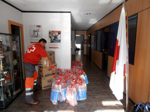 Un voluntari de Creu Roja preparant els lots de productes d'higiene i neteja de la llar.