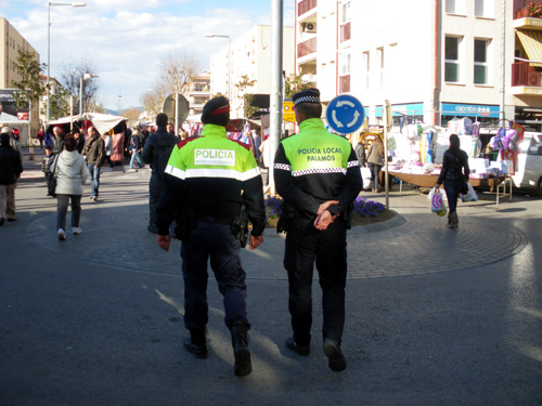 Un mosso d'esquadra i un policia local patrullen junts pel mercat de Palamós.