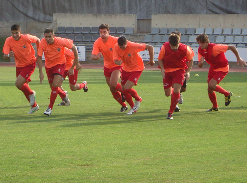 Els jugadors del Palamós CF s'escalfen abans d'un partit. (Foto: Sergi Cortés).