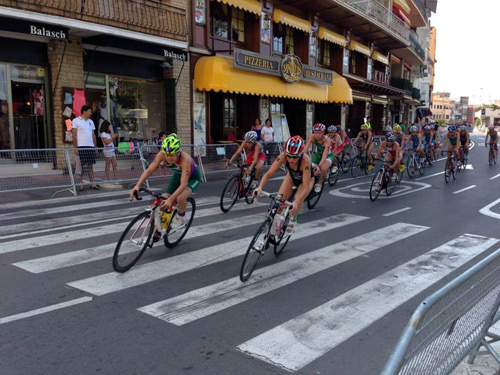 Participants del triatló passen pel centre urbà de Palamós.