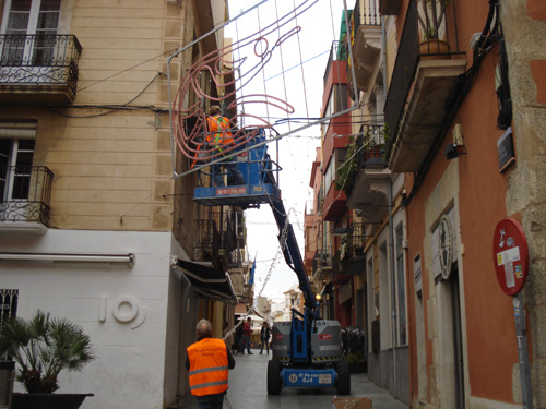 Operaris de la brigada instal·lant la il·luminació nadalenca al Carrer Major.