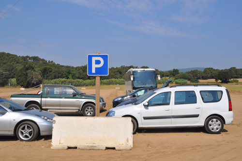 Vehicles estacionats a l'aparcament d'estiu de la platja de Castell.