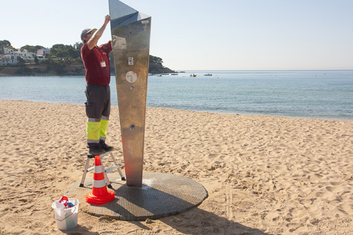 Un operari de Dipsalut revisa una dutxa a la platja. (Foto: Joana Magureanu).