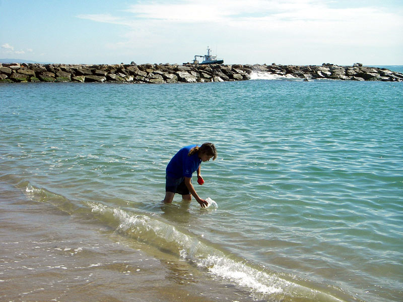 Representant de l'ACA agafant una mostra d'aigua de mar per valorar-ne la qualitat.