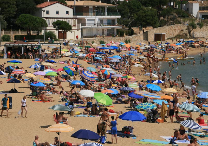 Turistes a la platja de La Fosca, aquest estiu. (Foto: Ràdio Palamós).