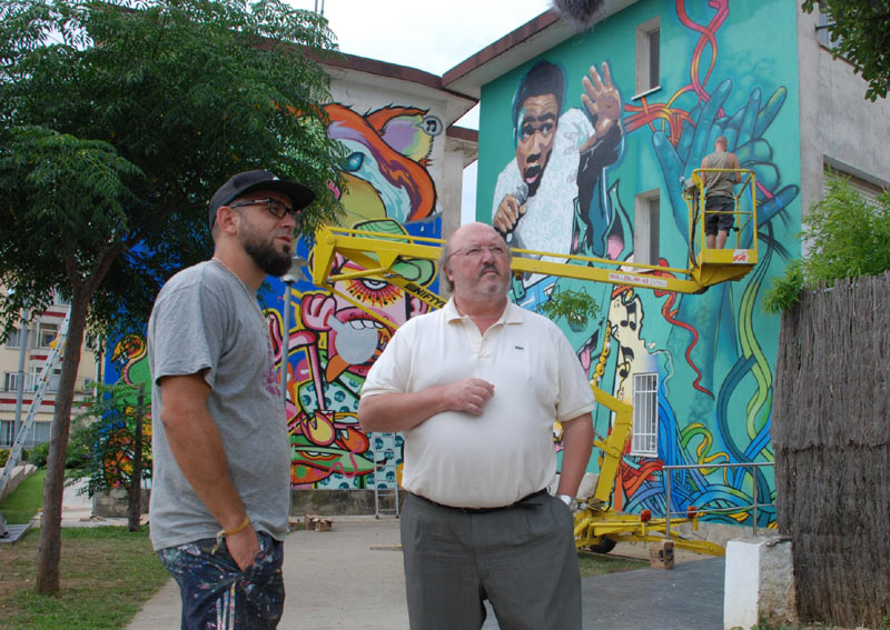 L'alcalde de Calonge, Jordi Soler, i l'artista urbà J.Loca, davant el mural. (Foto: Ajuntament de Calonge).