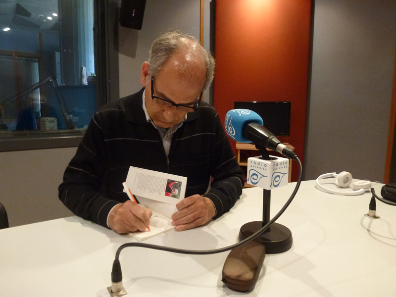 Feliu Antúnez firmant un exemplar del llibre, ahir a Ràdio Palamós.