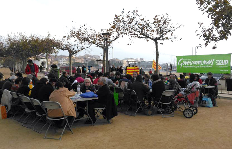 Els participants a l'Escupdellada d'aquest dissabte, dinant al passeig. (Foto: CUP Palamós i Sant Joan).