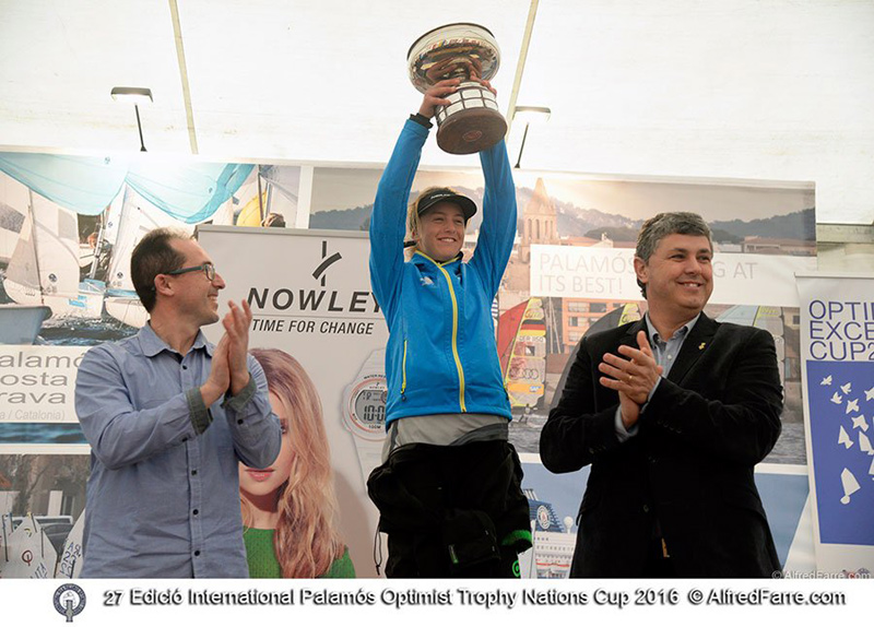 La italiana Gaia Bergonzini aixeca el trofeu que l'acredita com a guanyadora del Palamós Optimist Trophy. (Foto: Alfred Farré.)