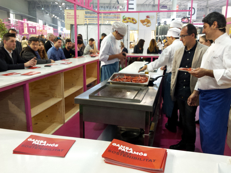 El cuiner Joan Cuadrat cuina unes gambes davant l'alcalde Lluís Puig a la Fira Alimentària.