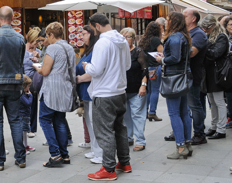 Gent pendent del mòbil ahir durant la jornada electoral. (Foto: Josep Lois)