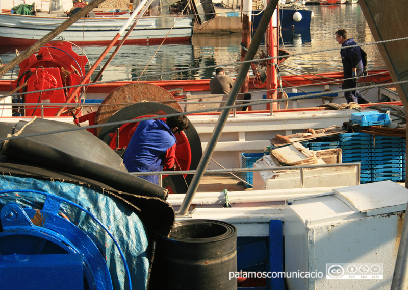 Feina de manteniment d'una barca al port de Palamós.