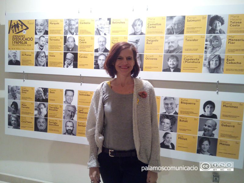 Anna Manso, davant l'exposició commemorativa amb tots els ponents que han passat pels 15 anys de les Jornades.