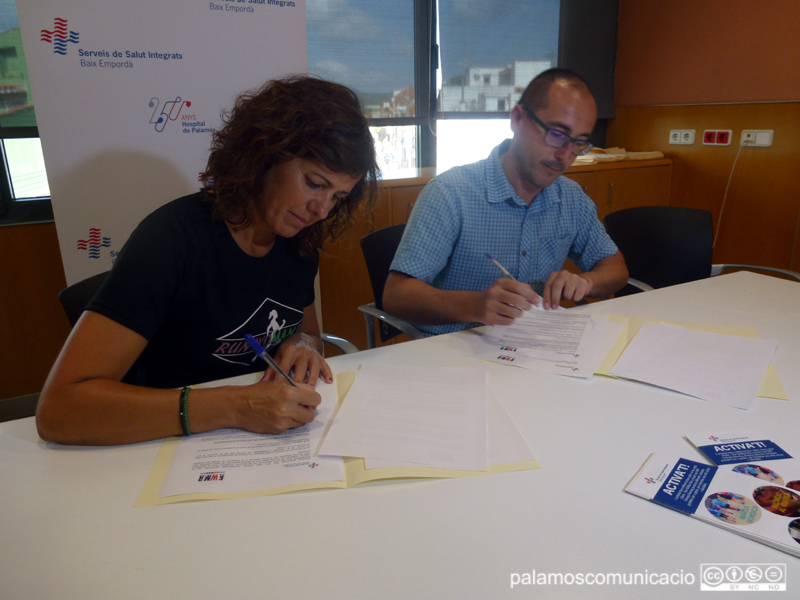 Judit Hidalgo, responsable de RunWomanRun, i l'alcalde i Patró de l'Hospital, Lluís Puig, durant la signatura del conveni.