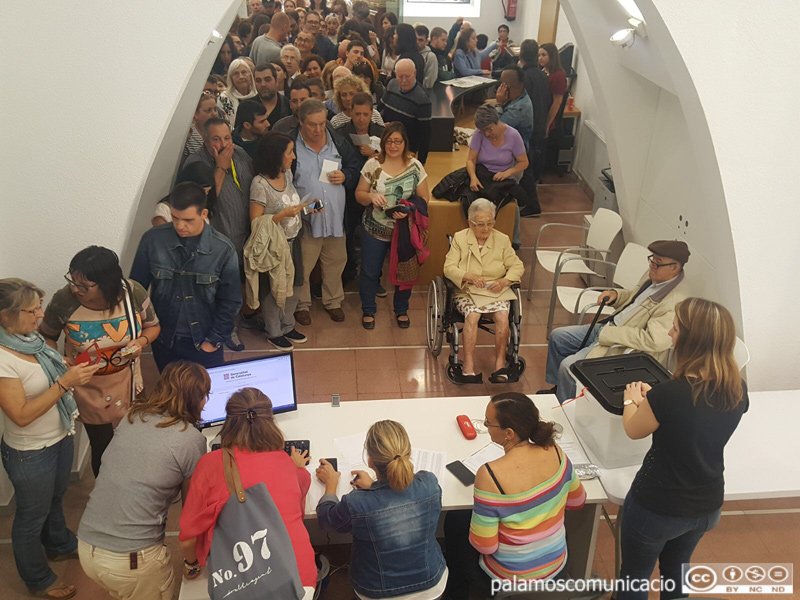 Gent votant el passat 1 d'octubre a la urna situada a l'Ajuntament de Palamós.