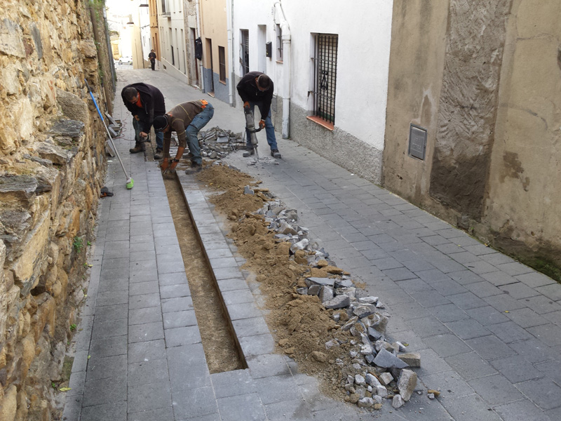 Operaris de la Brigada Municipal treballant en la reparació dels panots d'un tram del carrer d'Avall. (Foto: Ajuntament de Palamós).