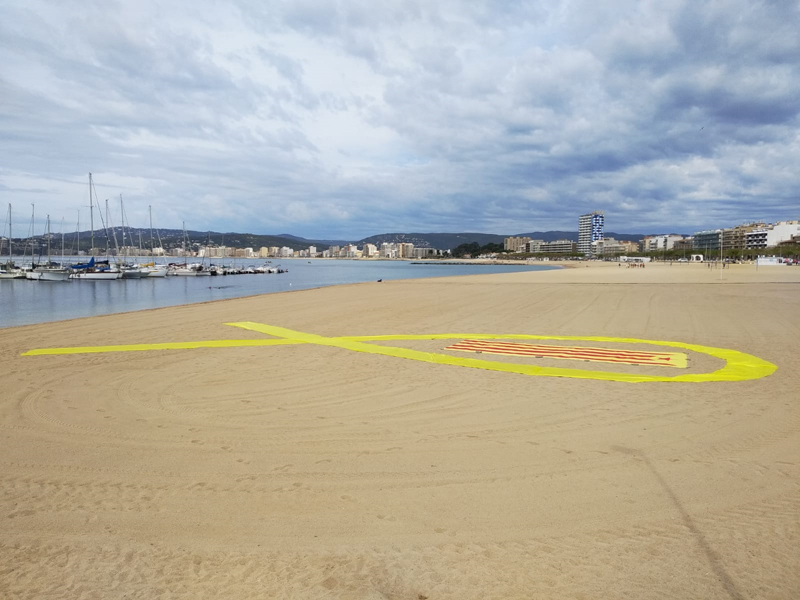 Els activistes van col•locar un gran llaç groc a la sorra de la platja Gran. (Foto: CDR Gavarres Mar).