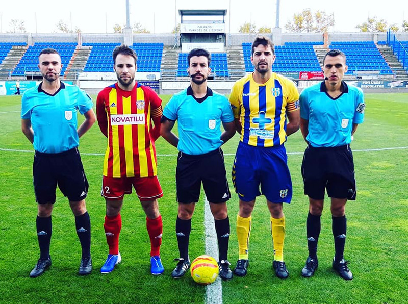 El capità David Cano, amb el seu homòleg del Manlleu i la tripleta arbitral, ahir abans del partit de diumenge. (Foto: Palamós CF).