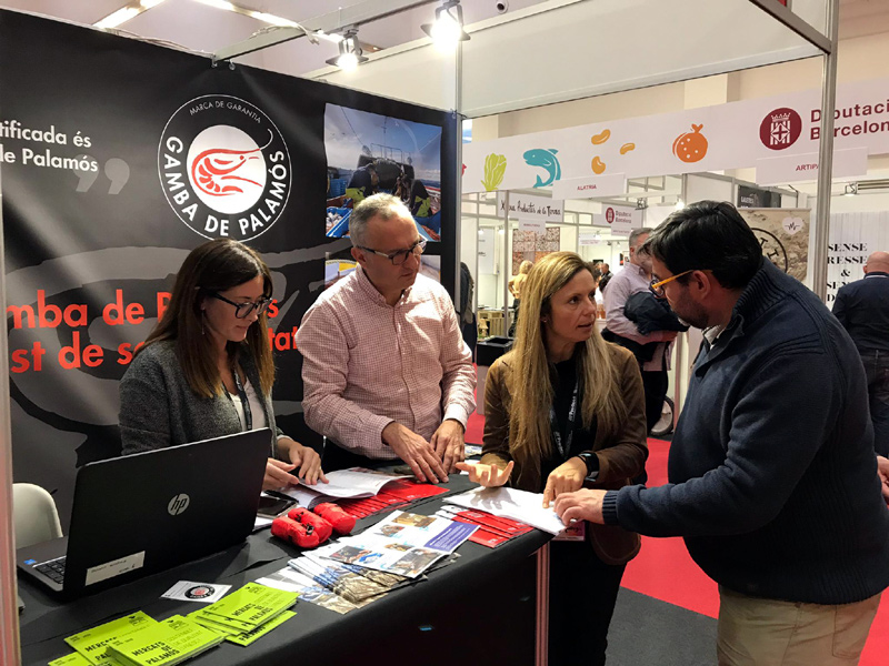 El regidor Emili Colls i la gerent de la Confraria, Cristina Mañas, atenent un visitant a l'estand. (Foto: Ajuntament de Palamós).