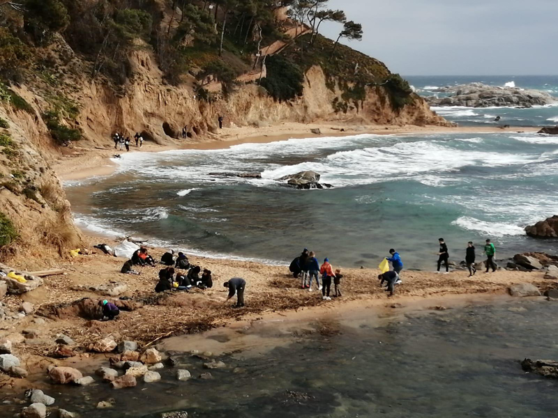 Esportistes i familiars del CE Palamós, recollint brossa a Cala Estreta. (Foto: Club Esportiu Palamós).