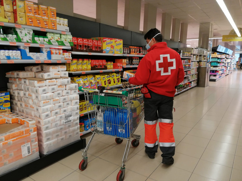 Personal de Creu Roja comprant material al supermercat que després portarà a domicili. (Foto: Creu Roja Palamós).