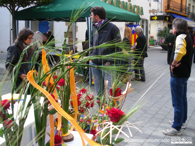 Parada de venda de roses d'una floristeria palamosina al carrer Major durant una Diada de Sant Jordi.