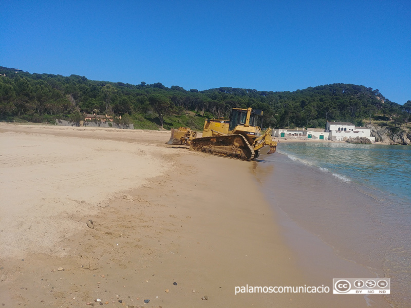 Excavadora aplanant la platja de Castell.