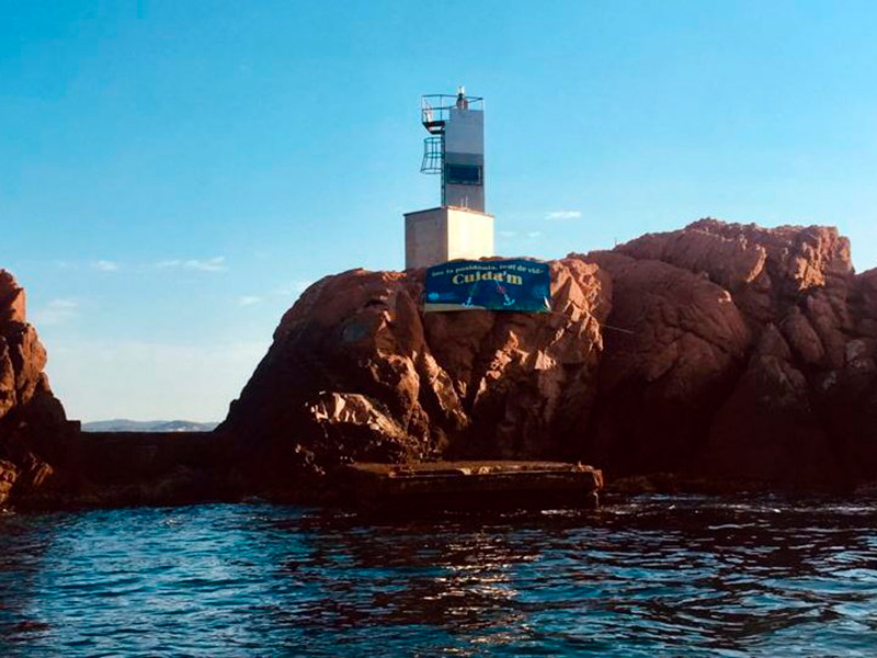 Les illes Formigues, amb la pancarta penjada per l'Associació Amics de les Illes Formigues.